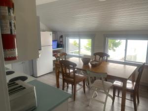 a kitchen with a table and chairs in a kitchen at Tofino Paddlers Inn in Tofino