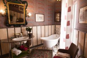 een badkamer met een bad, een wastafel en een spiegel bij B&B Palazzo Melluso in Porto Empedocle
