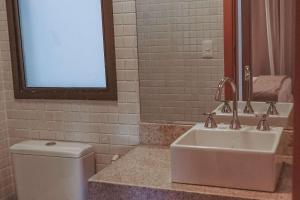 a bathroom with a sink and a toilet and a mirror at Samba Rio Convention & Residence in Rio de Janeiro