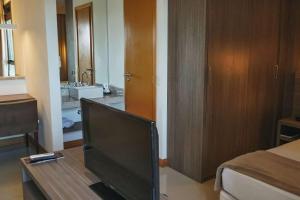a living room with a flat screen tv on a table at Samba Rio Convention & Residence in Rio de Janeiro