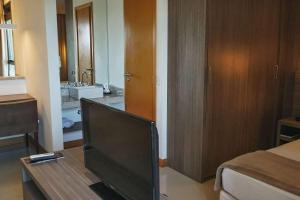 a living room with a television on a wooden table at Samba Rio Convention & Residence in Rio de Janeiro