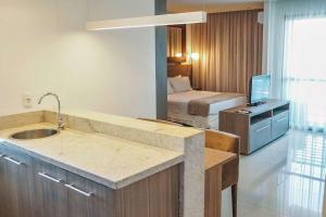 a bathroom with a sink and a bedroom with a bed at Samba Rio Convention & Residence in Rio de Janeiro