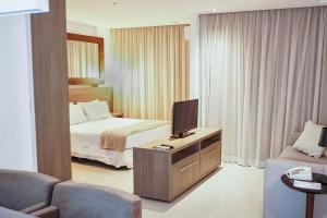 a hotel room with a bed and a television at Samba Rio Convention & Residence in Rio de Janeiro