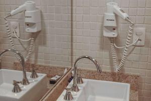 a bathroom with two sinks and two hair dryers at Samba Rio Convention & Residence in Rio de Janeiro
