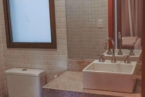 a bathroom with a sink and a toilet and a mirror at Samba Rio Convention & Residence in Rio de Janeiro