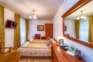 sypialnia z łóżkiem i dużym lustrem w obiekcie Pensjonat Skalny Szczawnica w mieście Szczawnica