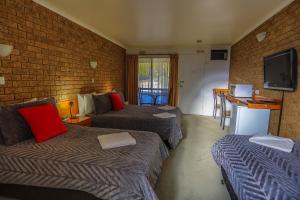 Habitación de hotel con 2 camas y TV en Mountain View Motor Inn & Holiday Lodges, en Halls Gap