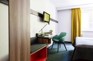 a hotel room with a bed and a desk and a chair at Good Morning Berlin City West in Berlin