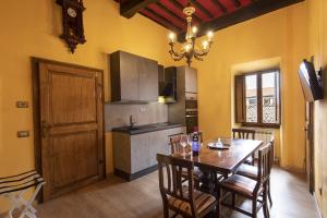 eine Küche mit einem Tisch und einem Esszimmer in der Unterkunft La Togata Hotellerie de Charme - Relais il Pozzo in Montalcino
