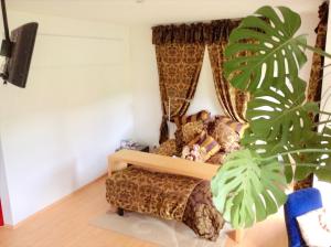 a bedroom with a bed and a large plant at Charming Villa with Private Swimmingpool in Attalens