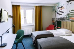 una camera d'albergo con due letti e una finestra di Good Morning Berlin City West a Berlino