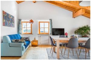 Lions Apartments في فِيي: غرفة معيشة مع أريكة زرقاء وطاولة