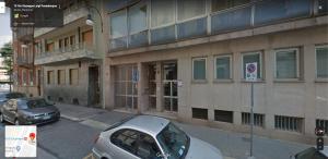 two cars parked in front of a building at Turin Central Rooms in Turin