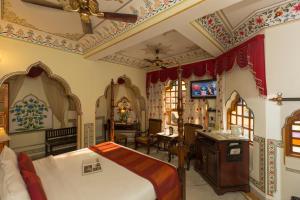 
a hotel room with a bed and a dresser at Umaid Bhawan - A Heritage Style Boutique Hotel in Jaipur
