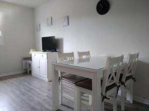 a white dining room table with chairs and a television at Residence Sun Hols Villas du Lac - Appartement 2 piéces 4 pers in Soustons