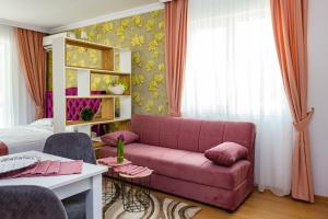 a living room with a pink couch and a bed at Sweet Homes 6 Apartments in Sunny Beach +120 photos