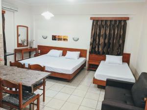a hotel room with two beds and a couch at Ionion Studios in Kanali