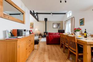 a kitchen and living room with a red couch at Criddlestyle Cottage - 5 bedroom New Forest Holiday Home in Fordingbridge