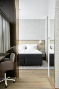 a bedroom with a bed and a desk and a chair at Tallink Spa & Conference Hotel in Tallinn