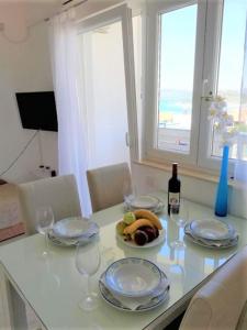 una mesa con una bandeja de fruta y una botella de vino en Apartments Janja, en Murter