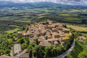 eine Luftansicht eines Dorfes in den Hügeln in der Unterkunft La Togata Hotellerie de Charme - Relais il Pozzo in Montalcino