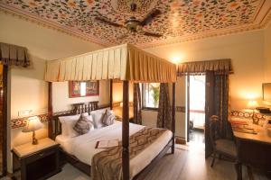 um quarto com uma cama e um tecto com papel de parede floral em Umaid Bhawan - A Heritage Style Boutique Hotel em Jaipur