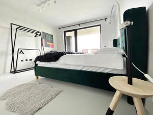 a bedroom with a large green bed and a stool at Cluj Apartments in Cluj-Napoca