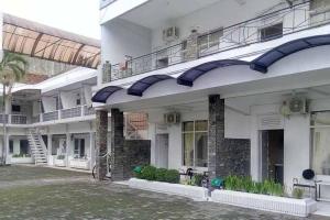 ein großes weißes Gebäude mit Balkon und Innenhof in der Unterkunft RedDoorz Syariah @ Hotel Kencana Tasikmalaya in Tasikmalaya