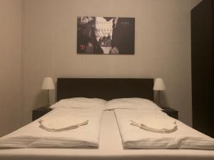 
a bed with a white bedspread and pillows on it at LAS PALMAS ROOMS in Štúrovo
