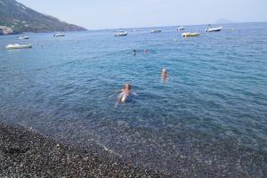 a group of people in the water at the beach at Lipari By The Beach in Lipari