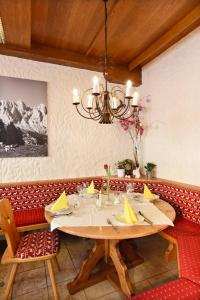 a dining room with a table and a chandelier at Heinrichshof in Mühlbach am Hochkönig