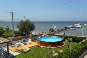 a swimming pool in a yard next to the ocean at La casa di Sina in Marsala +6 photos