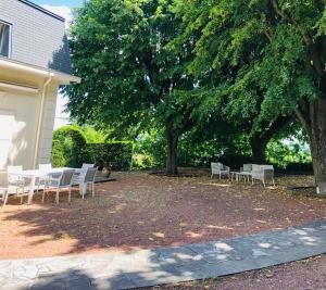 a group of tables and chairs under a tree at La Souveraine in Saint-Genis-Laval