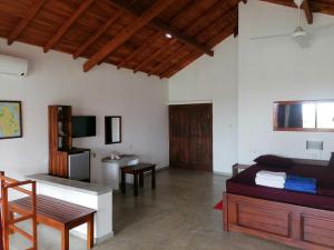 a room with a bed and a desk and a kitchen at Ladja Beach Resort in Ambalantota
