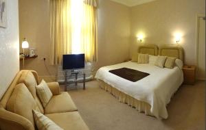 a bedroom with a large bed and a television at The Chudleigh in Clacton-on-Sea