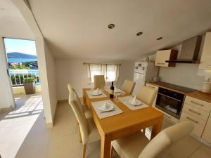 a kitchen and dining room with a wooden table and chairs at Apartment D&D Grubišić in Grebaštica