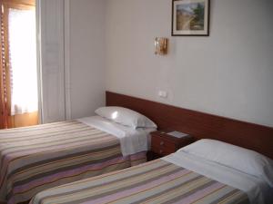 a hotel room with two beds and a window at Hostal Tudescos in Madrid