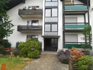 an apartment building with a front door and flowers at Ferienwohnung Ziegelbergblick in Jockgrim