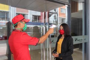 a man taking a picture of a woman wearing a red mask at Swiss-Belhotel Cirebon in Cirebon