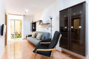 a living room with a couch and a tv at Apartamentos Ohana - Edificio Tonillo in Los Cristianos