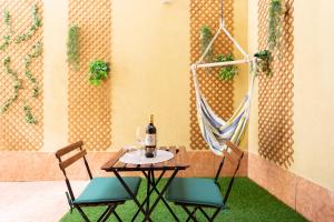 a table with two chairs and a bottle of wine at Apartamentos Ohana - Edificio Tonillo in Los Cristianos