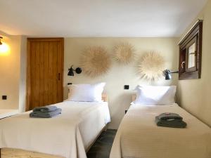 Dos camas en una habitación con toallas. en Pelion Homes, en Agios Georgios Nilias