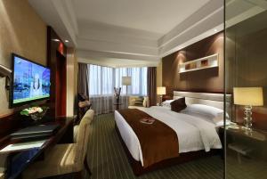 a hotel room with a large bed and a television at Kunming Haitian Hotel in Kunming