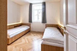 2 Betten in einem kleinen Zimmer mit Fenster in der Unterkunft Apartment Genziana in St. Ulrich in Gröden