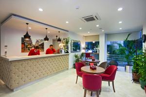 a restaurant with a bar with red chairs and a counter at The Room Hotel & Apartments in Antalya