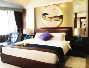 a bedroom with a large bed and a blue chair at Kunming Haitian Hotel in Kunming