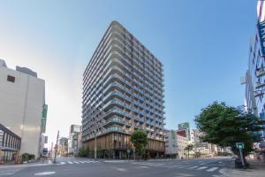 a tall building on a street in a city at Miyako City Osaka Hommachi in Osaka