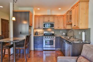a kitchen with wooden cabinets and a table and a stove at Columbia Cliff Villas in Hood River