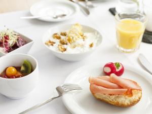 una mesa blanca con un plato de comida y bebida en Villa Siegfried en Bad Steben