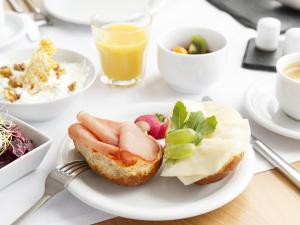 einen Tisch mit einem Teller Essen und einem Sandwich in der Unterkunft Villa Siegfried in Bad Steben